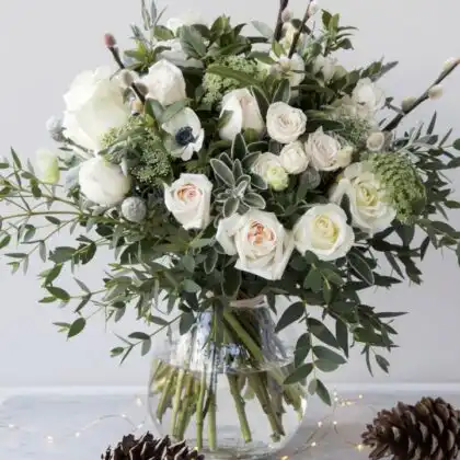 Hand-tied white rose and peony bouquet accented with delicate eucalyptus leaves and white ribbon.