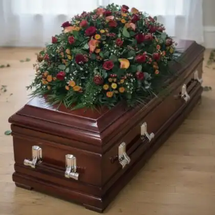 A grand 5ft coffin spray meticulously crafted with vibrant red roses and elegant white calla lilies for a funeral service.