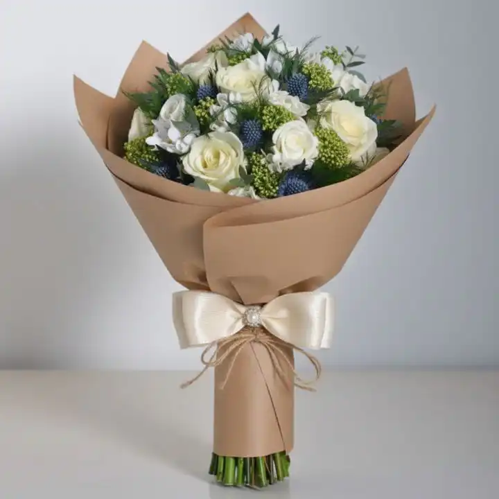 Rustic White Rose & Blue Thistle Dream 1 A stunning white rose and blue thistle bouquet arranged with green foliage for a rustic wedding theme.