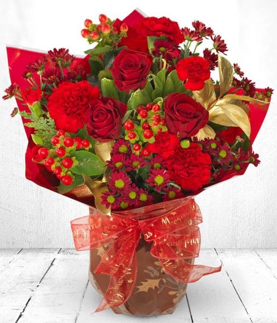 Rose, Carnation Berry Mixed Flower Bouquet 1 Christmas Berry Rose Bouquet featuring red roses, seasonal berries, and greenery for a festive holiday gift.