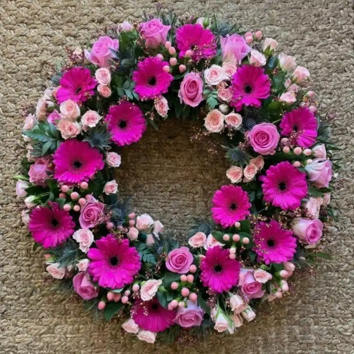 Eternal Pink Gerbera Memorial Wreath 1 A circular memorial arrangement of pink gerbera flowers wreaths funerals services to honor loved ones.