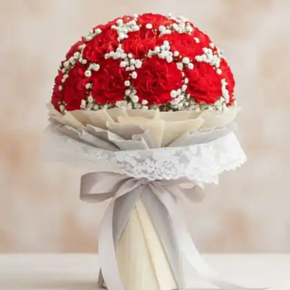 A stunning red carnation bridal bouquet paired with delicate white gypsophila and green foliage for a wedding ceremony.