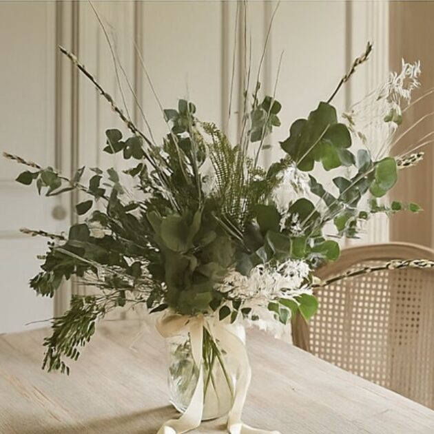 Christmas foliage bouquet 1 A lush, airy bouquet of assorted green and dried white foliage, eucalyptus, and tall grasses in a glass vase tied with a ribbon. Christmas foliage bouquet for sales