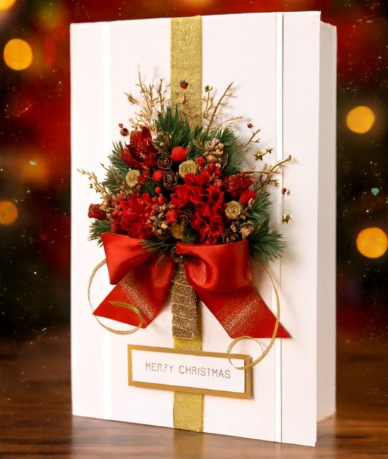 Christmas gift card ( Most Luxury card ) 1 A luxurious white Christmas gift card decorated with a red floral/pine tree design, gold ribbon, and a large red satin bow.