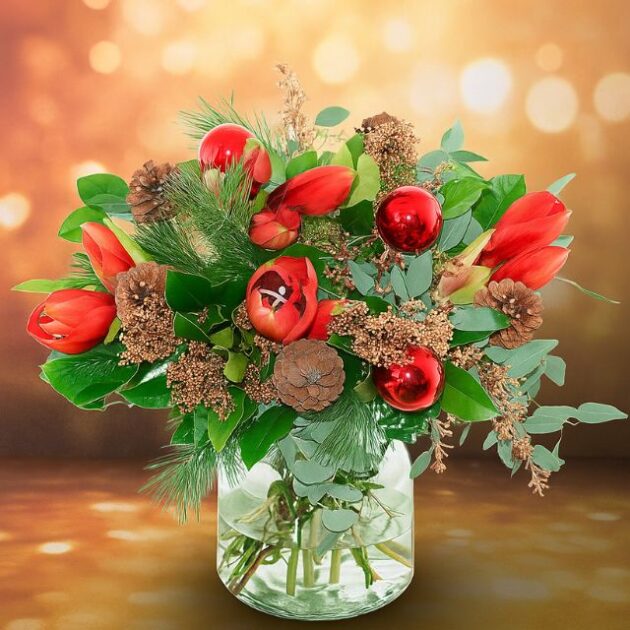 Decorative Christmas flowers 1 A vibrant Christmas vase arrangement with red tulips, shiny baubles, pine cones, and green foliage, available for delivery Christmas Eve. Decorative Christmas flowers for sale