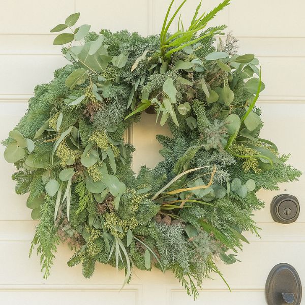 Large Christmas Ramble Wreath 1 A highly detailed, oversized Large Christmas Ramble Wreath featuring a mix of forest greenery, pinecones, and red ribbon, perfect for outdoor display.